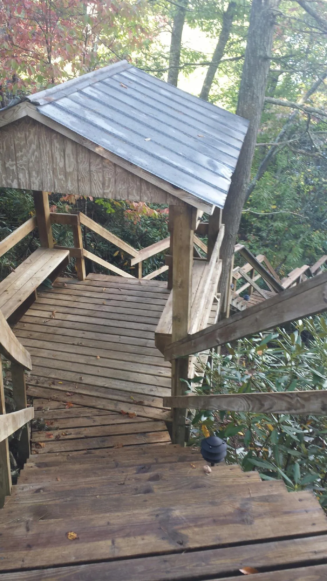 Metal roofed shelter over wooden steps on a wooded walkway — Skylight Repair & Installation work by our crew in Shrewsbury